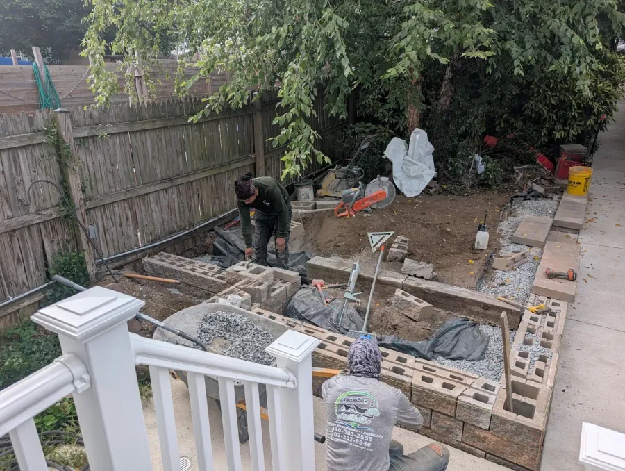 Crew building the retaining wall base and setting Techo-Bloc units during construction